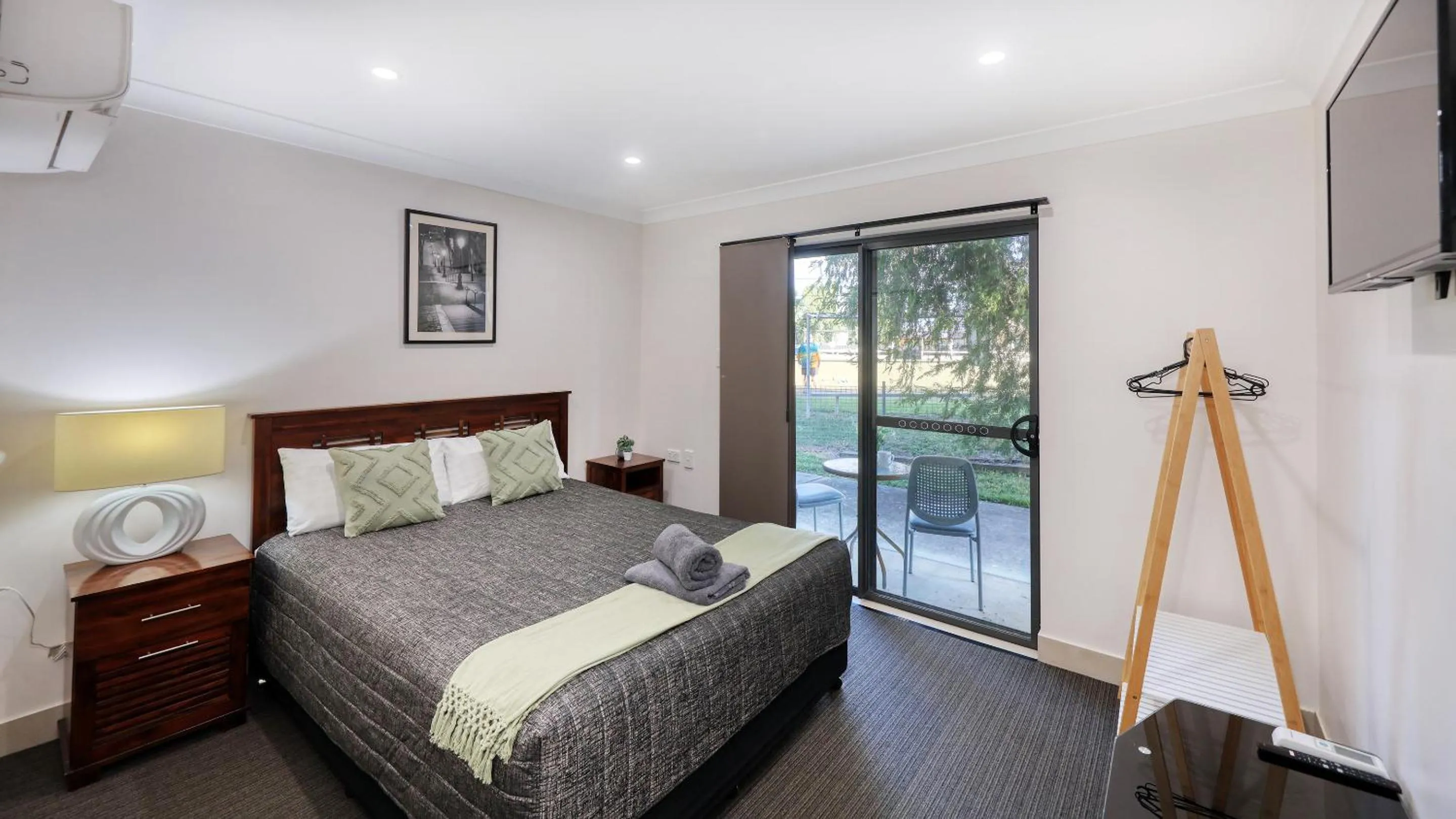 Patio, Bed in Emerald Gardens Motel & Apartments