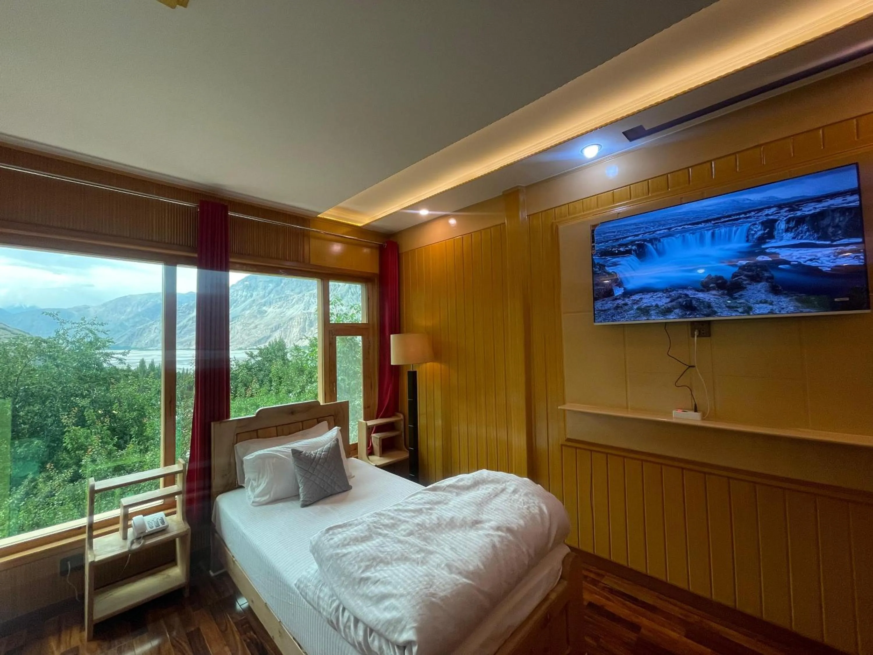 Communal lounge/ TV room, Bed in North Palace Khaplu