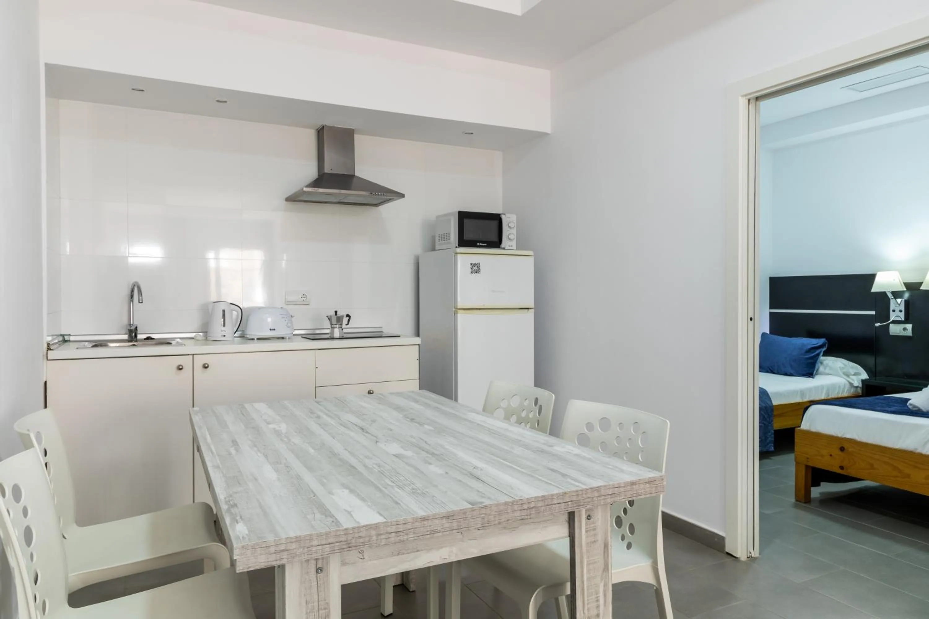 Kitchen or kitchenette, Bed in Aparthotel Puerto Cala Vadella